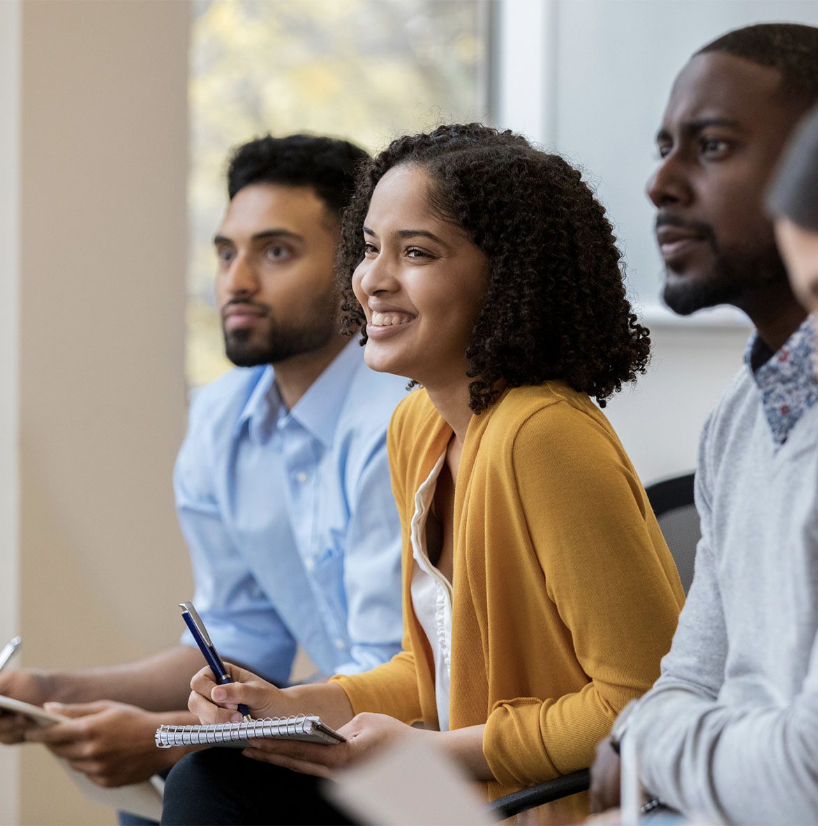 three people listening and taking notes