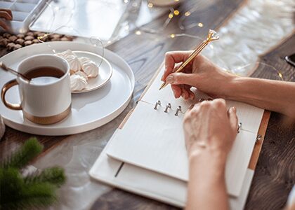 Hands writing in a planner