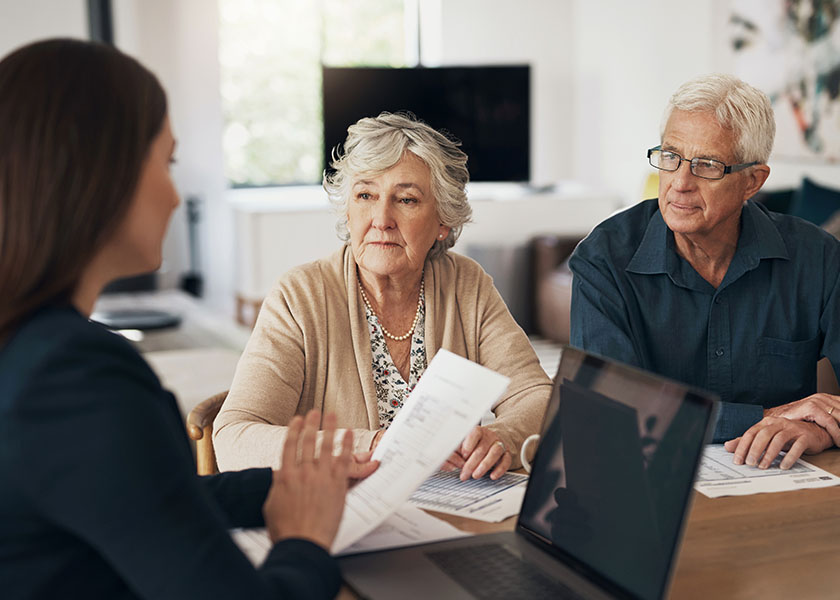 Couple meeting with financial advisor discuss how to choose a trustee.